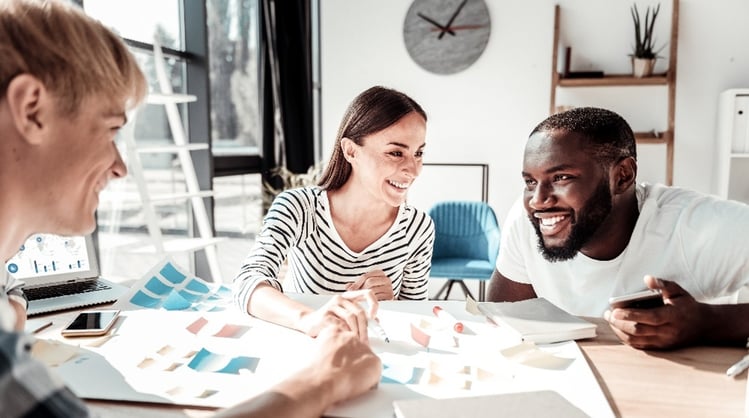 young diverse coworkers laughing together at work desk-1
