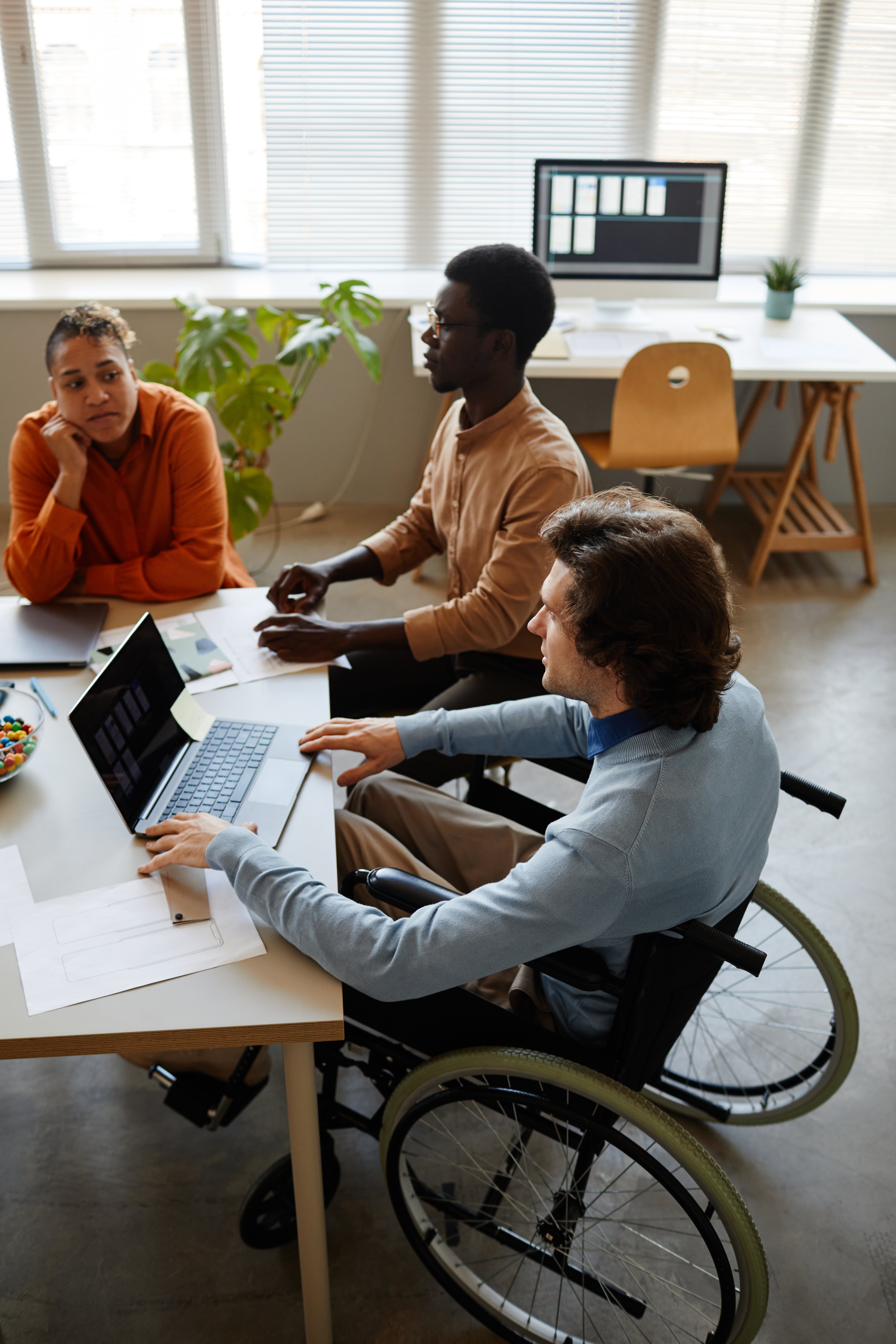 a man in a wheelchair working at a table