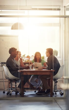 an office room with people meeting at a table