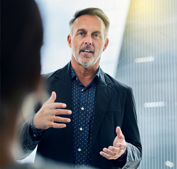 mature male in sportcoat giving presentation