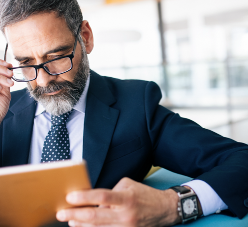 business man wearing suit and glasses studies documents