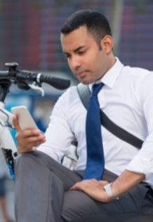 male office worker wearing tie checking health stats on phone