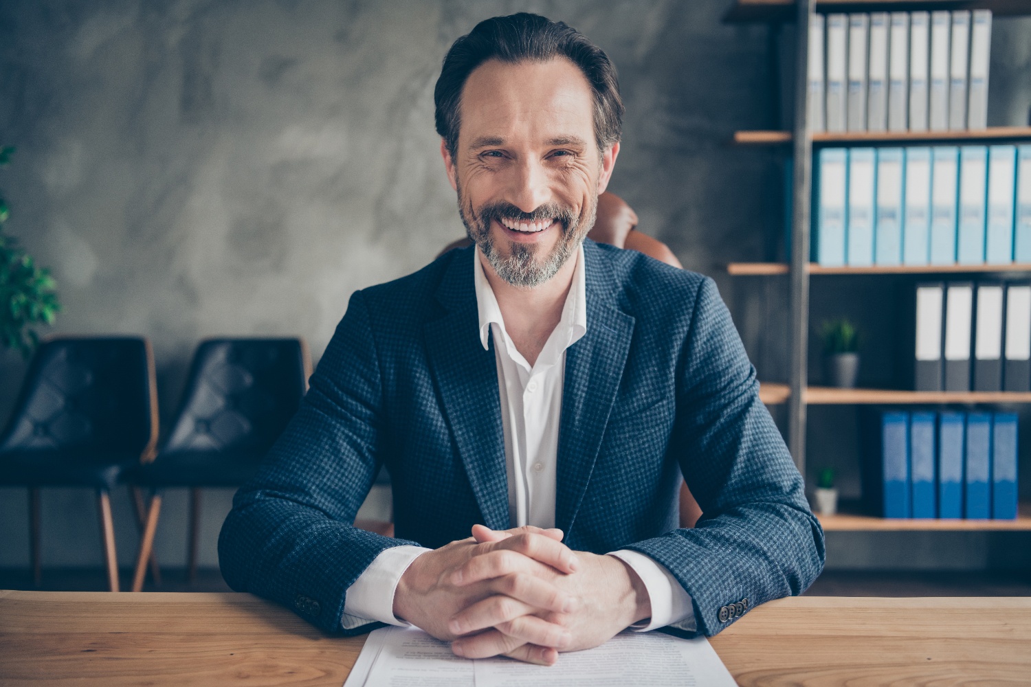smiling mature male in office sitting at desk